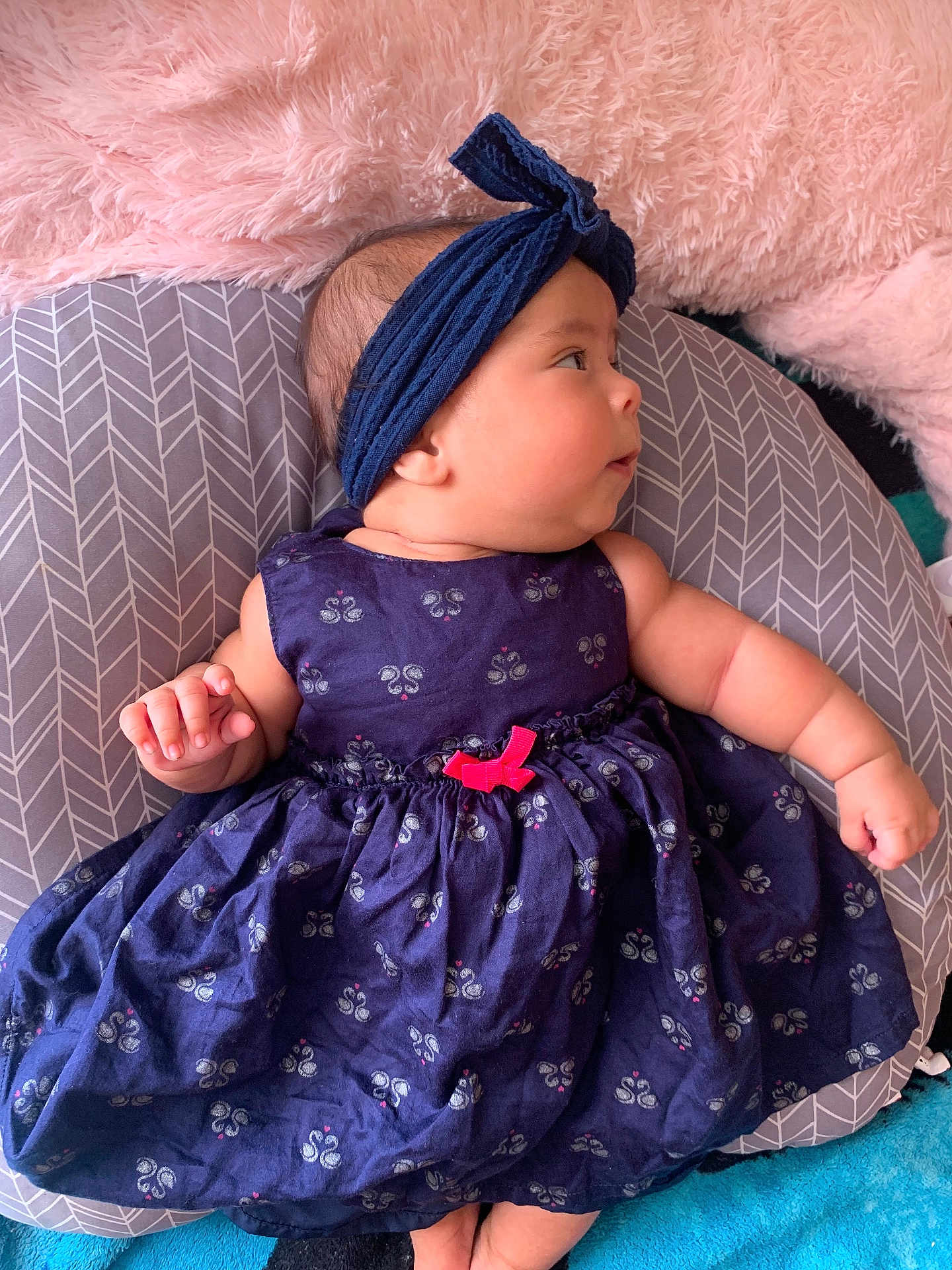 Estefany joined the competition — help win amazing prizes! baby, infant, dress, headband, pink, blue, cushion, pattern, soft_texture, lying_down, curious, chubby_cheeks, clothing, fabric, indoor, portrait, child, cute, person, comfortable