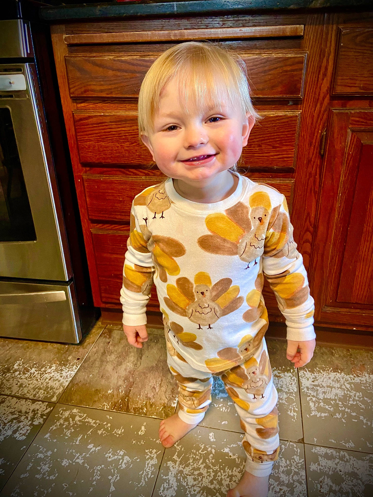 Ryder joined the competition — help win amazing prizes! baby_toddler_clothing, cabinetry, child, door, facial_expression, floor, flooring, fun, happy, hardwood, joy, pattern, person, sitting, sleeve, smile, standing, t_shirt, toddler, varnish