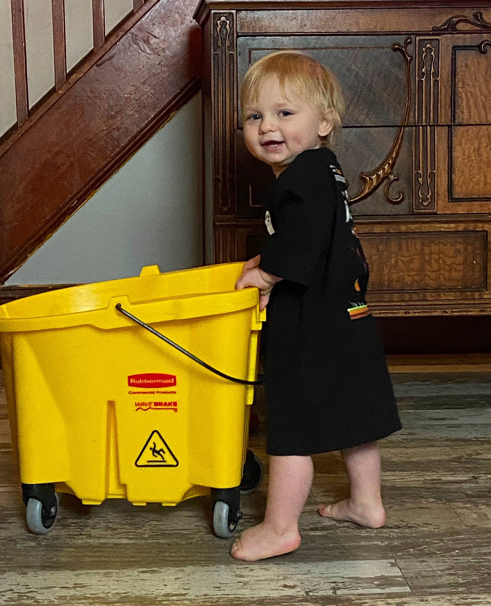 Ryder is registered to the contest to win money with this photo: chair, child, dress, flooring, formal_wear, fun, joy, organ, person, sandal, sitting, smile, standing, suit, toddler, vintage_clothing, waste_collector, waste_container, waste_containment, wheel