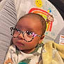 Dameon is registered to the contest to win money with this photo: baby, blanket, pacifier, glasses_filter, infant, seat, cute, child, indoors, portrait, cozy, yellow, green, animal_print, cartoon, face, head, clothing, sleepwear, toddler