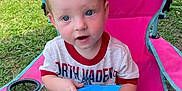 Hayes is registered to the contest to win money with this photo: baby, backyard, blue_fabric, blue_shorts, casual_clothing, child, curious, darth_vader_shirt, daylight, grass, greenery, outdoor, person, pink_chair, playful, relaxing, seat, summer, sunlight, toddler