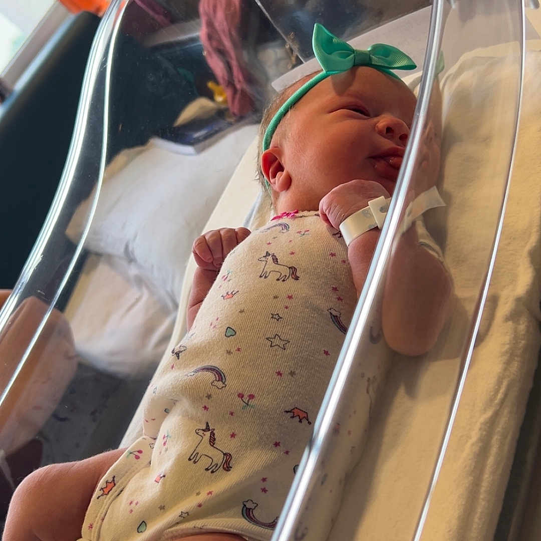 Harmonie is registered to the contest to win money with this photo: adult, architecture, baby, bed, bodypart, building, cradle, crib, face, finger, furniture, hand, head, hospital, infantbed, male, man, newborn, person, photography