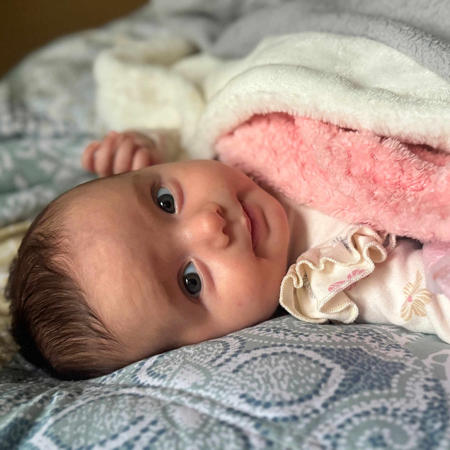 Zlata is registered to the contest to win money with this photo: baby, bed, blanket, clothing, comfort, cozy, cute, expression, face, head, indoors, infant, lying_down, pattern, skin, sleepwear, smile, soft, warm, young_child