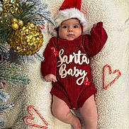 Ayla is registered to the contest to win money with this photo: baby, infant, christmas, holiday, santa_hat, red_sweater, candy_cane, heart_shape, golden_ornament, pine_tree, blanket, festive, cute, holiday_decor, christmas_tree, smiling, indoors, soft_texture, cozy, seasonal