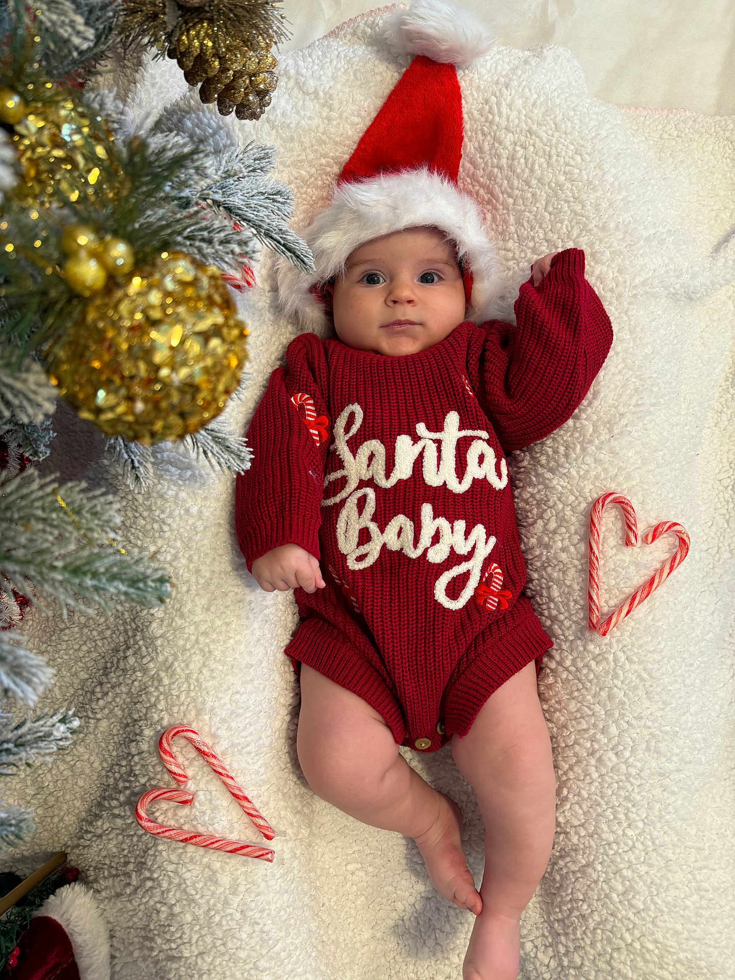 Ayla is registered to the contest to win money with this photo: baby, infant, christmas, holiday, santa_hat, red_sweater, candy_cane, heart_shape, golden_ornament, pine_tree, blanket, festive, cute, holiday_decor, christmas_tree, smiling, indoors, soft_texture, cozy, seasonal