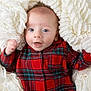 Grayson is registered to the contest to win money with this photo: baby, infant, plaid_clothing, red, blanket, white, soft_texture, cute, smiling, face, portrait, child, newborn, cozy, warm, hands, blue_eyes, lying_down, toddler, indoors