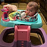 baby, blanket, carpet, child, colorful, couch, curious, face, floor, footwear, furniture, head, indoor, living_room, person, plush_toy, seated, socks, toy, walker