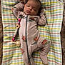 baby, infant, sleeping, blanket, onesie, pacifier, pacifier_clip, beads, floral_pattern, striped_blanket, cozy, nap, cute, portrait, indoor, soft_texture, hand, footie_pajamas, peaceful, resting