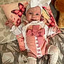 baby, infant, smiling, headband, bow, pink_outfit, white_socks, cushion, butterfly, plush_toy, bed, blanket, cute, child, portrait, happy, indoor, clothing, fabric, person