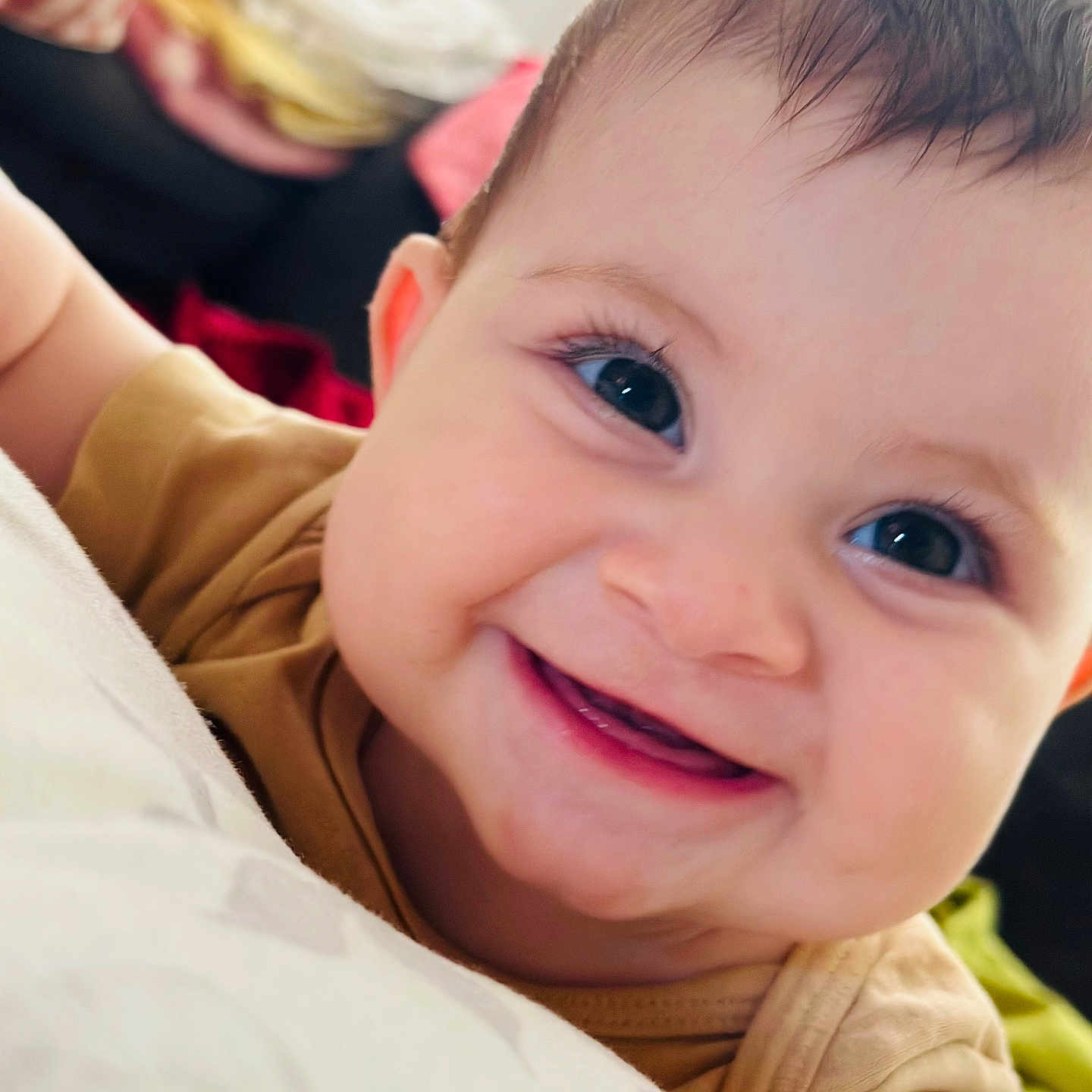 Eveline participe au concours pour gagner de l'argent avec cette photo : baby, blanket, child, close_up, clothing, cushion, cute, eyes, face, happy, head, indoors, infant, mouth, person, portrait, skin, smiling, soft_surface, teeth