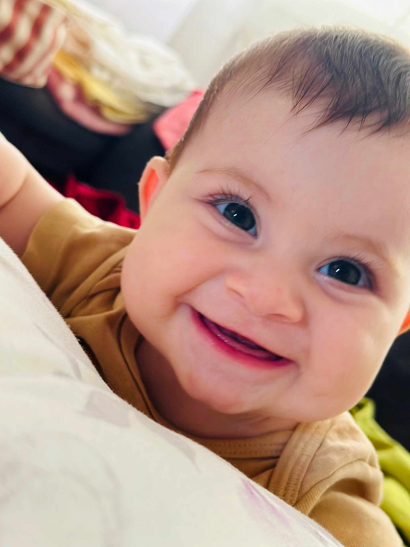 Eveline participe au concours pour gagner de l'argent avec cette photo : baby, smiling, close_up, face, child, infant, happy, eyes, skin, mouth, teeth, clothing, head, indoors, soft_surface, blanket, cushion, person, cute, portrait