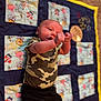 Theodore joined the competition — help win amazing prizes! baby, infant, child, camouflage, shirt, pants, quilt, patchwork, blanket, carpet, floor, lying_down, hands, face, curious, indoors, young, person, cute, cozy