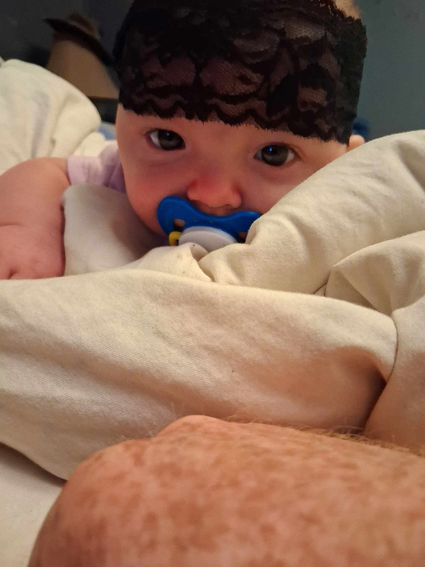 Rebel is registered to the contest to win money with this photo: baby, pacifier, blanket, face, headband, arm, skin, bed, sleepwear, closeup, indoor, infant, person, cute, rest, comfort, soft, expression, young, lying