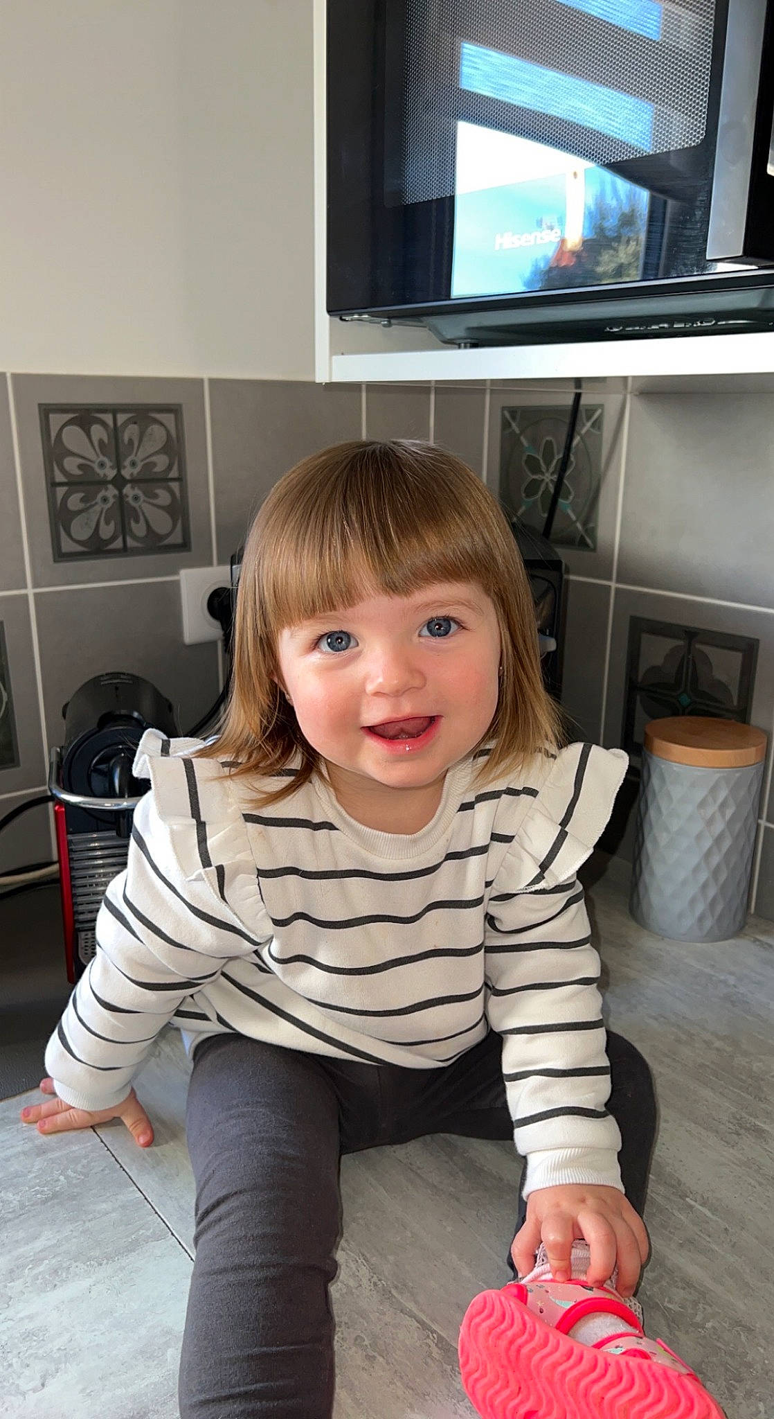 Milla participe au concours pour gagner de l'argent avec cette photo : cable_television, child, entertainment_center, eye, face, floor, flooring, fun, hairstyle, happy, hardwood, home_appliance, joy, person, shoulder, sleeve, smile, t_shirt, television, television_set