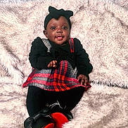 Melody joined the competition — help win amazing prizes! baby, child, smiling, sitting, plaid, black_clothing, headband, shoe, red, black, blanket, fluffy, cute, portrait, happy, indoors, cozy, fashion, person, infant