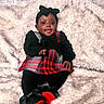 baby, child, smiling, sitting, plaid, black_clothing, headband, shoe, red, black, blanket, fluffy, cute, portrait, happy, indoors, cozy, fashion, person, infant