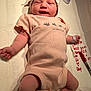 newborn, baby, infant, onesie, hat, wristband, ankleband, hospital, marker, notes, lying_down, face, skin, person, clothing, bed, textile, comfort, peaceful, cute