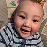 baby, smiling, infant, striped_clothing, blue, face, child, cute, happy, onesie, sitting, indoor, playful, animal_pattern, monkey, colorful, baby_seat, closeup, head, cheerful