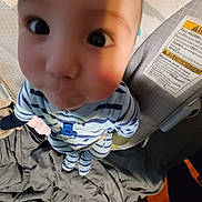 Laios joined the competition — help win amazing prizes! baby, child, pajamas, striped_clothing, face, wide_eyes, shadow, close_up, indoor, blanket, crib, furniture, cute, infant, person, sleepwear, bed, curious, expression, soft_lighting