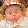 baby, child, face, hat, straw_hat, pout, curious_eyes, white_shirt, portrait, closeup, cute, infant, person, headwear, expression, young_child, indoors, warm_colors, soft_light, casual_clothing
