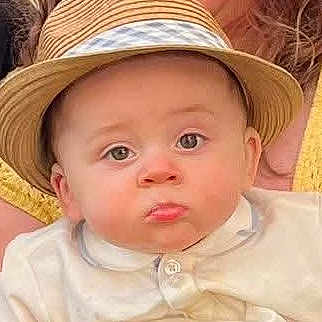 Jackson joined the competition — help win amazing prizes! baby, child, face, hat, straw_hat, pout, curious_eyes, white_shirt, portrait, closeup, cute, infant, person, headwear, expression, young_child, indoors, warm_colors, soft_light, casual_clothing