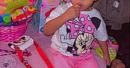 Stormi Lynn Punter is registered to the contest to win money with this photo: child, toddler, pink_pants, minnie_mouse, hair_accessories, balloon, doll, gift_bags, toys, couch, table, party, socks, indoor, person, clothing, hair, face, sitting, celebration