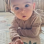 baby, child, infant, play_mat, hand, face, eyes, curious, indoors, home, floor, pattern, clothing, long_sleeve, crawling, young, human, cute, expression, soft_light