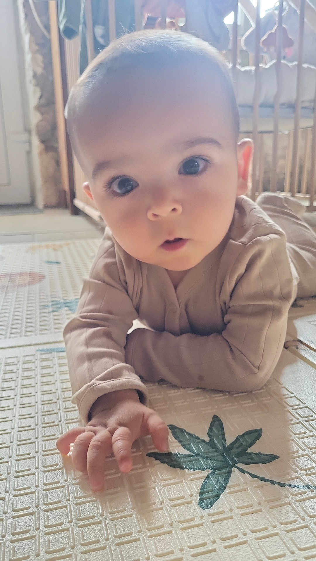 Malo participe au concours pour gagner de l'argent avec cette photo : baby, child, infant, play_mat, hand, face, eyes, curious, indoors, home, floor, pattern, clothing, long_sleeve, crawling, young, human, cute, expression, soft_light
