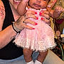 Mckenna Brook is registered to the contest to win money with this photo: woman, baby, child, holding, pink_dress, socks, tattoos, smiling, indoor, person, happy, cute, family, skin, face, hand, fingers, seated, jeans, portrait