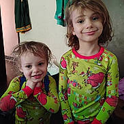 Scarlett joined the competition — help win amazing prizes! child, children, pajamas, green, grinch, smile, happy, indoor, clothing, person, cute, hair, holiday, festive, portrait, two_people, standing, young, family, room