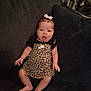 baby, infant, child, couch, clothing, leopard_print, nike, bow, sitting, expression, face, indoors, furniture, person, footwear, cute, skin, legs, hand, headwear