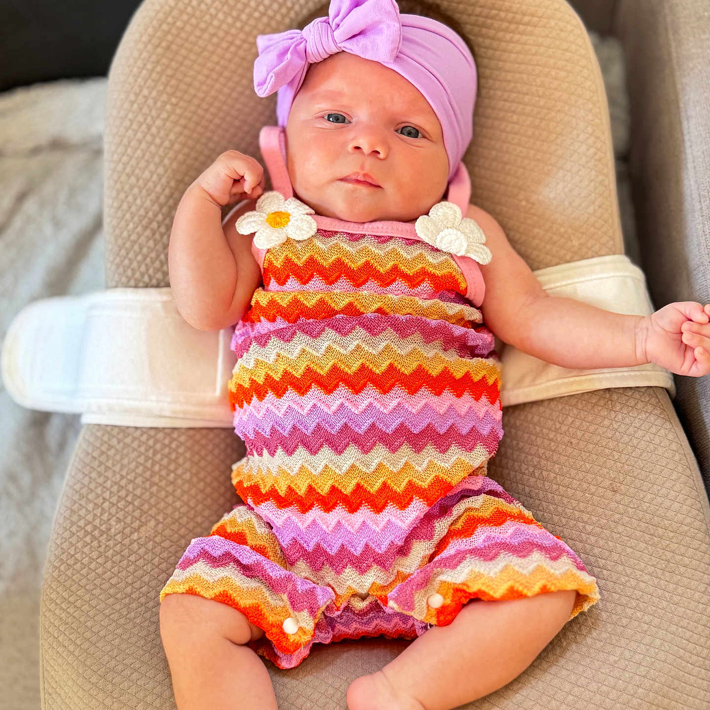 Solé a rejoint le concours — aidez-le/la à gagner de superbes lots ! baby, barefoot, beige, bow, calm_expression, child, colorful_clothing, comfortable, cushion, cute, fashion, headband, indoors, infant, person, reclining, romper, soft_lighting, texture, zigzag_pattern
