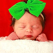 Josette joined the competition — help win amazing prizes! newborn, baby, infant, sleeping, green_bow, headband, blanket, white_blanket, red_background, face, peaceful, cute, wrapped, portrait, closeup, soft_texture, skin, tiny_hands, resting, indoors