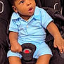 baby, black_car_seat, blue_clothing, car_seat, child, clothing, curious, cute, expression, face, hand, indoor, infant, person, portrait, seat_belt, sitting, socks, toddler, young_child