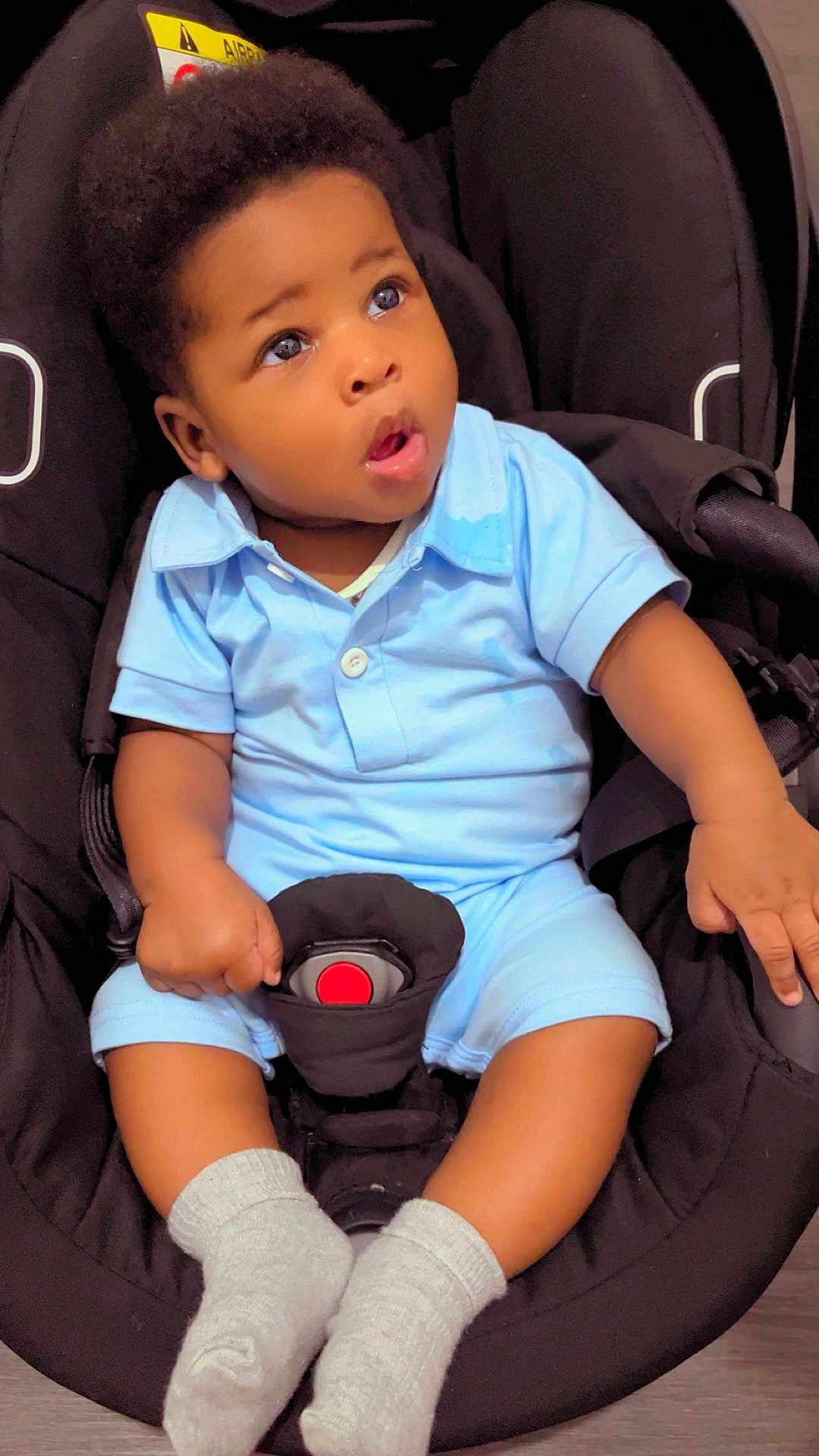 Shaun Leeroy Andrew a rejoint le concours — aidez-le/la à gagner de superbes lots ! baby, black_car_seat, blue_clothing, car_seat, child, clothing, curious, cute, expression, face, hand, indoor, infant, person, portrait, seat_belt, sitting, socks, toddler, young_child