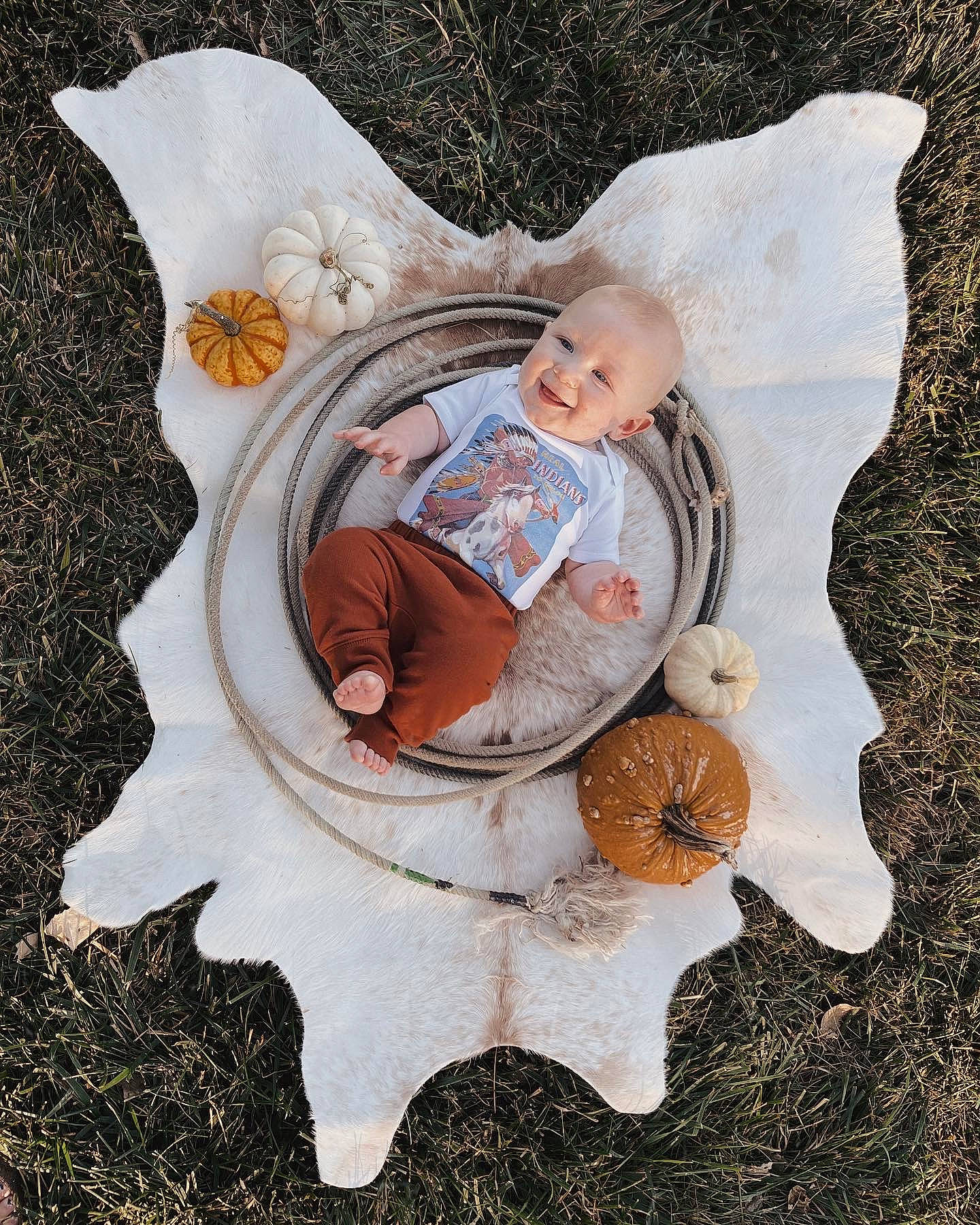 Brantlee is registered to the contest to win money with this photo: art, baby, baby_products, baby_toddler_clothing, child, comfort, fashion_accessory, fictional_character, grass, happy, head, illustration, leaf, linens, pattern, person, sitting, textile, toddler, tree