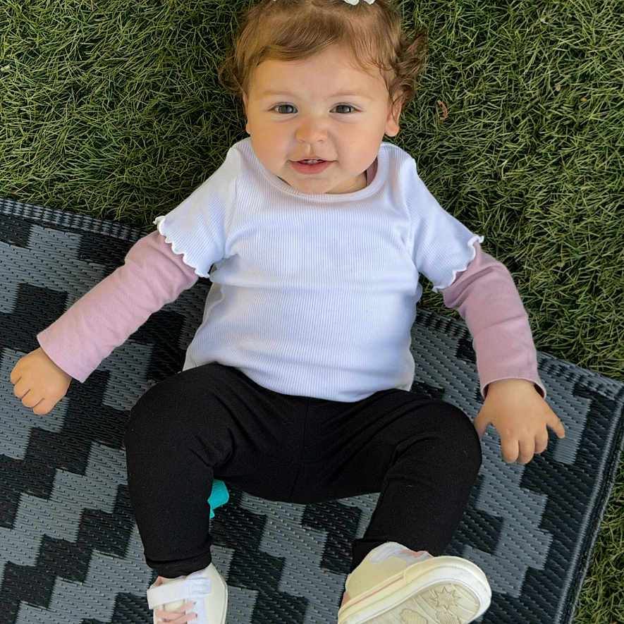Nevaeh joined the competition — help win amazing prizes! accessories, baby, bodypart, clothing, face, finger, footwear, grass, hand, head, homedecor, mat, pants, person, photography, plant, portrait, shoe, sitting, sneaker