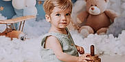 Malo participe au concours pour gagner de l'argent avec cette photo : toddler, child, toy, wooden_toy, stacking_toy, teddy_bear, balloons, crescent_moon, clouds, airplane_toy, indoor, portrait, cute, playful, soft_lighting, nursery, smiling, sitting, baby_clothes, decor