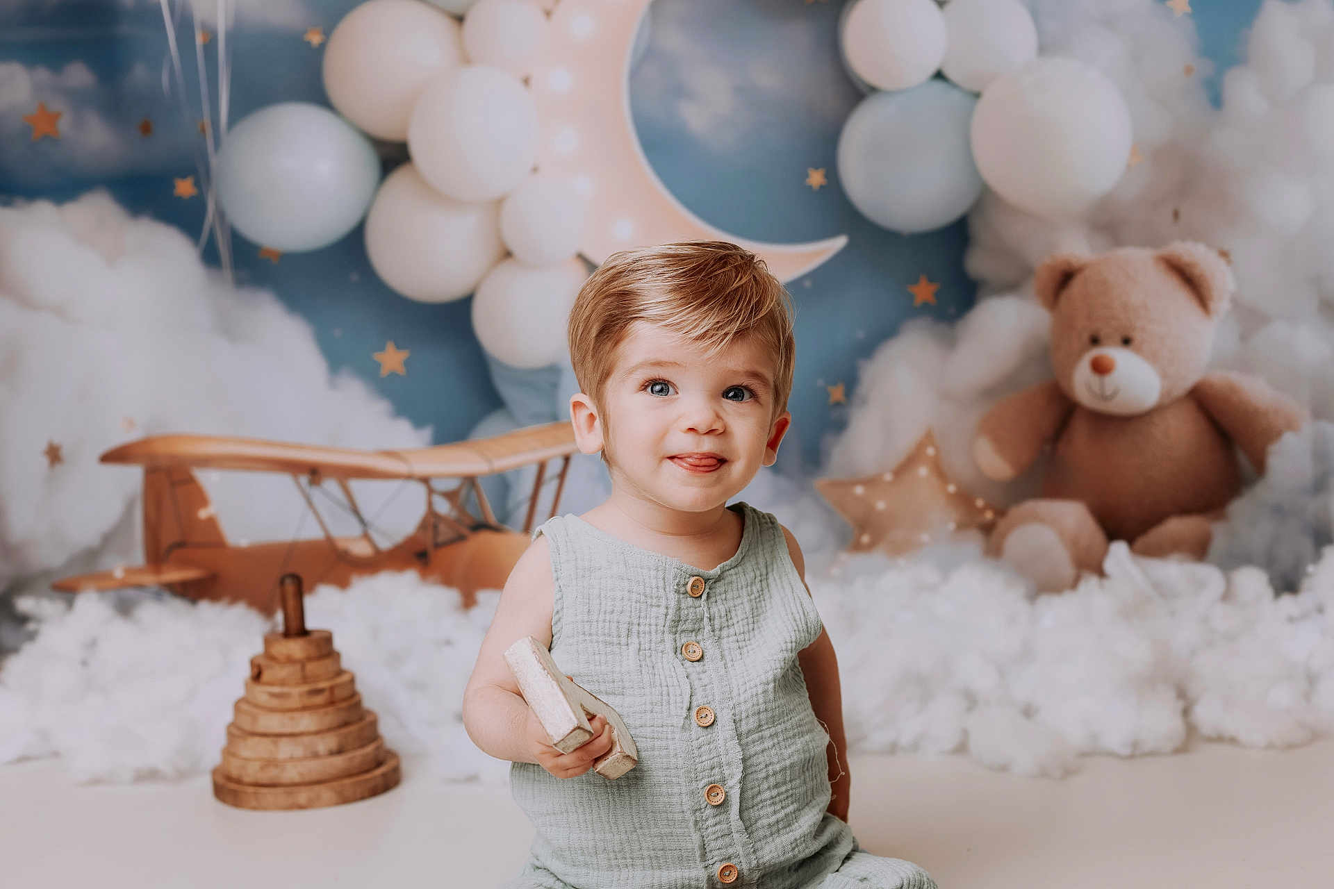 Malo participe au concours pour gagner de l'argent avec cette photo : toddler, child, smile, tongue_out, toy, wooden_toy, balloons, crescent_moon, stars, clouds, teddy_bear, wooden_airplane, nursery, indoor, portrait, cute, happy, playful, soft_lighting, decor