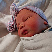 Jaylyn is registered to the contest to win money with this photo: baby, newborn, infant, swaddled, blanket, hat, bow, sleeping, face, cheek, hospital_blanket, closeup, portrait, peaceful, soft_texture, skin, newborn_cap, bedding, resting, head