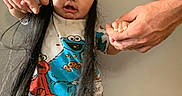 Ali joined the competition — help win amazing prizes! baby, child, infant, portrait, indoors, pajamas, cookie_monster, green_hat, long_hair, wide_eyes, looking_at_camera, adult_hands, playful, colorful_clothing, cartoon_characters, gray_wall, standing, family, close_up, funny_pose