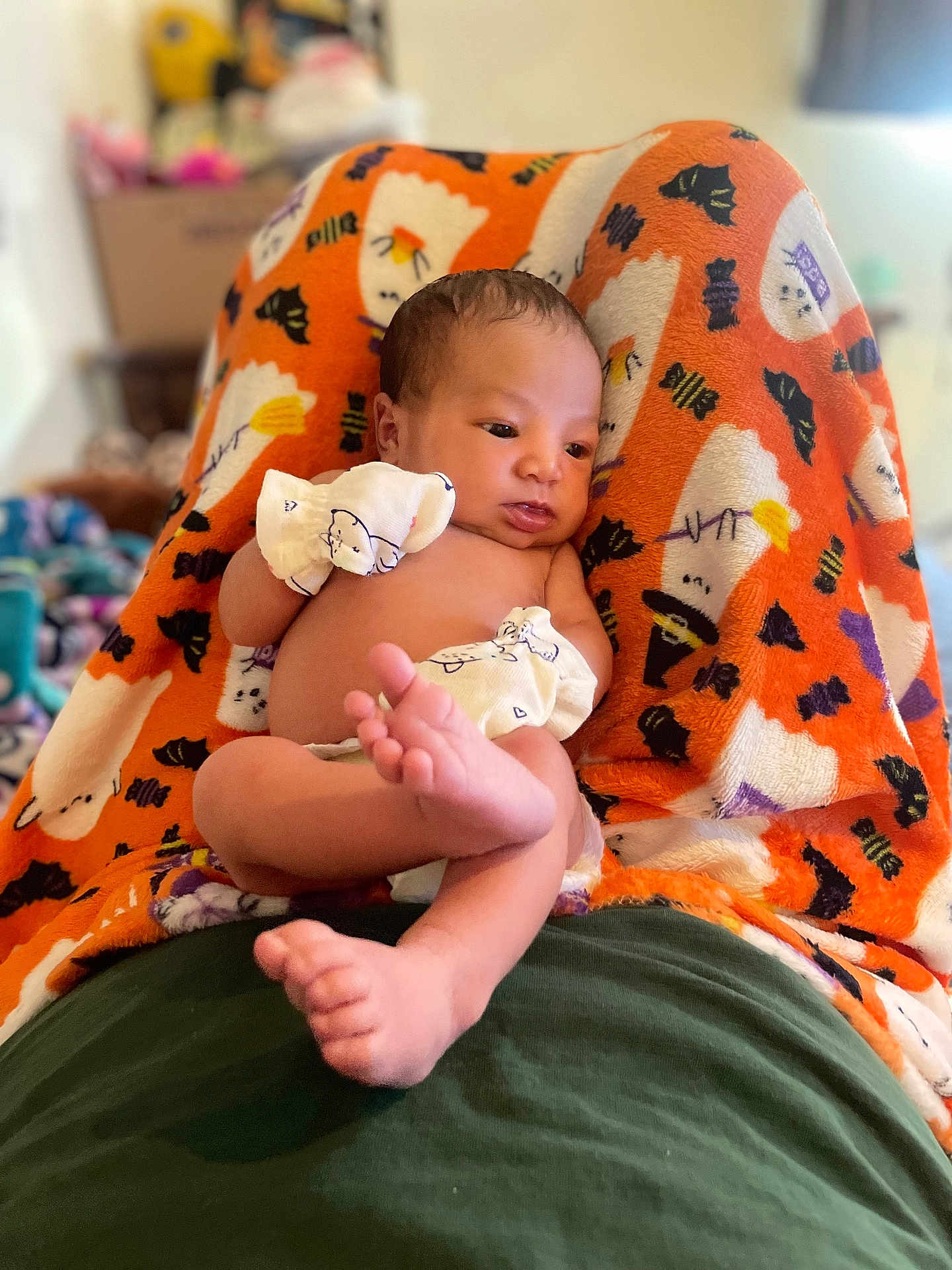 Alìze joined the competition — help win amazing prizes! baby, infant, blanket, orange, mittens, lying_down, cute, indoors, soft_texture, pattern, foot, hand, skin, face, newborn, relaxed, colorful, person, comfort, cozy