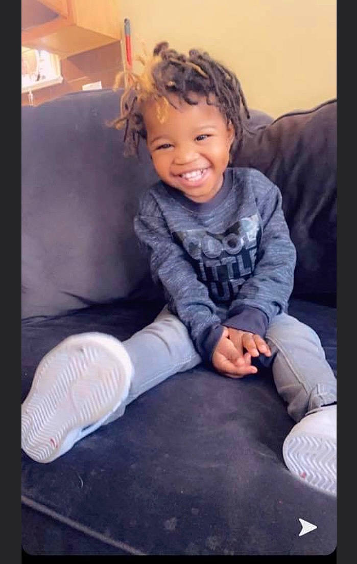 Cartier is registered to the contest to win money with this photo: baby_toddler_clothing, comfort, denim, face, finger, flash_photography, flooring, fun, happy, human_leg, joy, knee, leg, person, sitting, sleeve, smile, sock, t_shirt, thigh