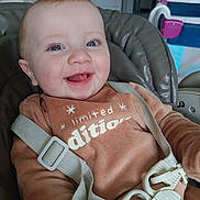 Aksel participe au concours pour gagner de l'argent avec cette photo : baby, infant, smiling, happy, blue_eyes, seat, car_seat, harness, buckle, onesie, clothing, close_up, portrait, indoor, playpen, kitchen, pacifier, hand, cheerful, cute