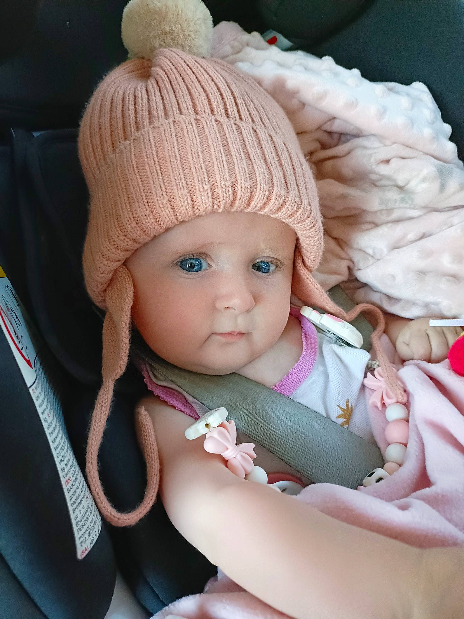 Eva participe au concours pour gagner de l'argent avec cette photo : baby, baby_toddler_clothing, cap, cheek, child, comfort, eye, eyelash, finger, head, headgear, headwear, human_body, knit_cap, person, pink, skin, textile, thumb, toddler