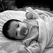 Ada participe au concours pour gagner de l'argent avec cette photo : baby, infant, blanket, pacifier, clothing, face, head, soft_texture, bed, sleepwear, newborn, cute, portrait, lying_down, indoors, comfort, peaceful, baby_bib, black_and_white, young_child