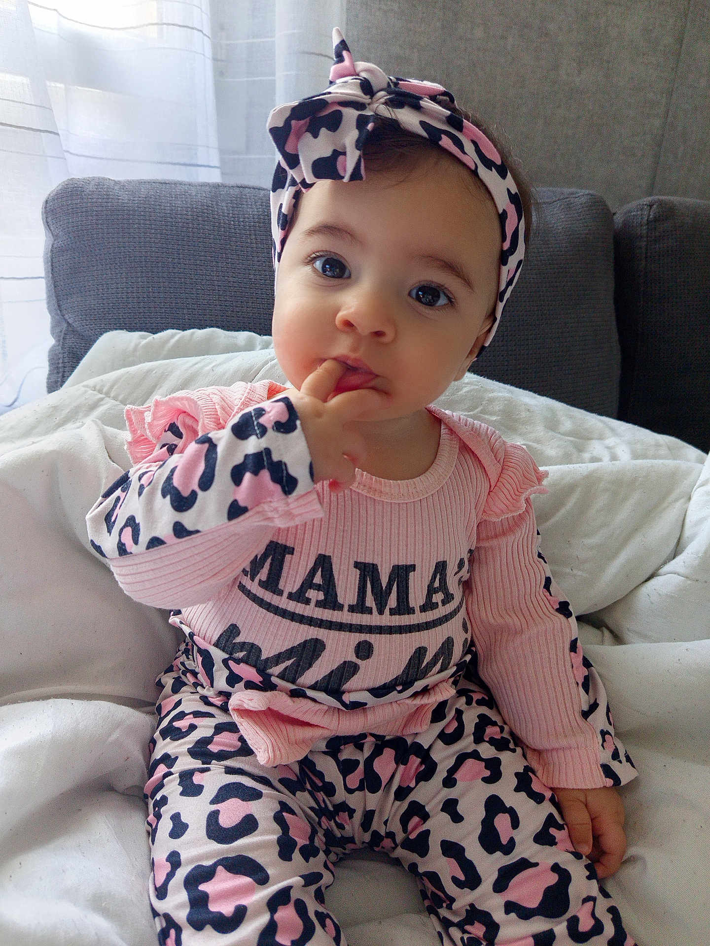Alana participe au concours pour gagner de l'argent avec cette photo : baby, infant, child, cute, pink_clothing, headband, leopard_print, sitting, indoor, portrait, cozy, bed, blanket, curious, fingers_in_mouth, soft_light, candid, comfortable, smiling_eyes, young_child