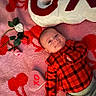 Kaizen is registered to the contest to win money with this photo: adorable, artificial_roses, baby, child, cozy, cute, green_leaves, happy, heart_pattern, indoors, infant, laying_down, pink_blanket, plaid_shirt, portrait, red_clothing, smiling, soft_texture, valentine_theme, xo_pillow