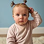 baby, toddler, child, pigtails, pink_outfit, blue_wall, rug, portrait, indoor, sitting, curious_expression, big_eyes, soft_lighting, closeup, innocence, cute, long_eyelashes, plush_rug, minimal_background, one_person