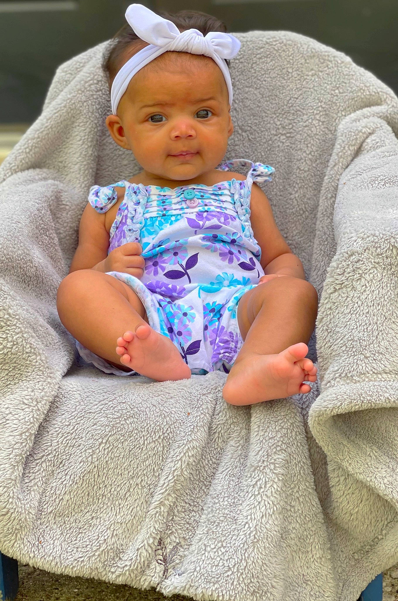 Meela is registered to the contest to win money with this photo: baby, baby_products, baby_toddler_clothing, cheek, child, comfort, face, facial_expression, fashion_accessory, headgear, headwear, linens, pattern, person, pink, purple, sitting, skin, sleeve, textile